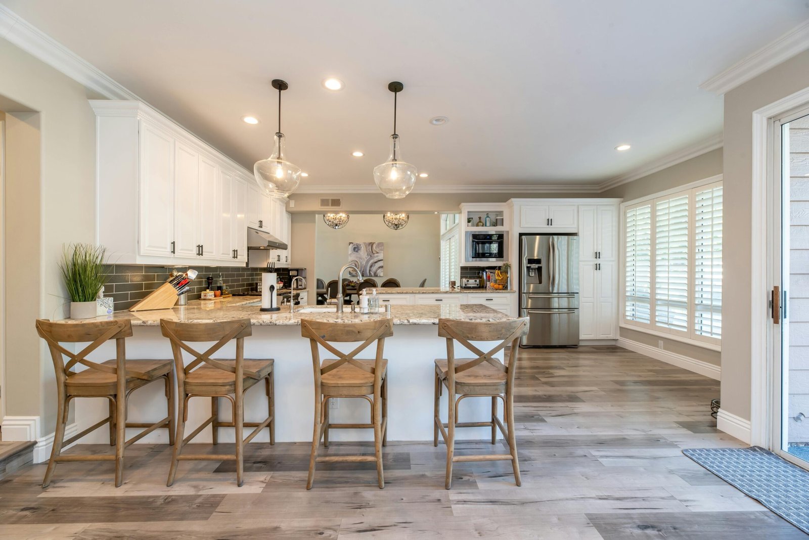 Bright and spacious kitchen interior featuring bar stools and modern design elements.