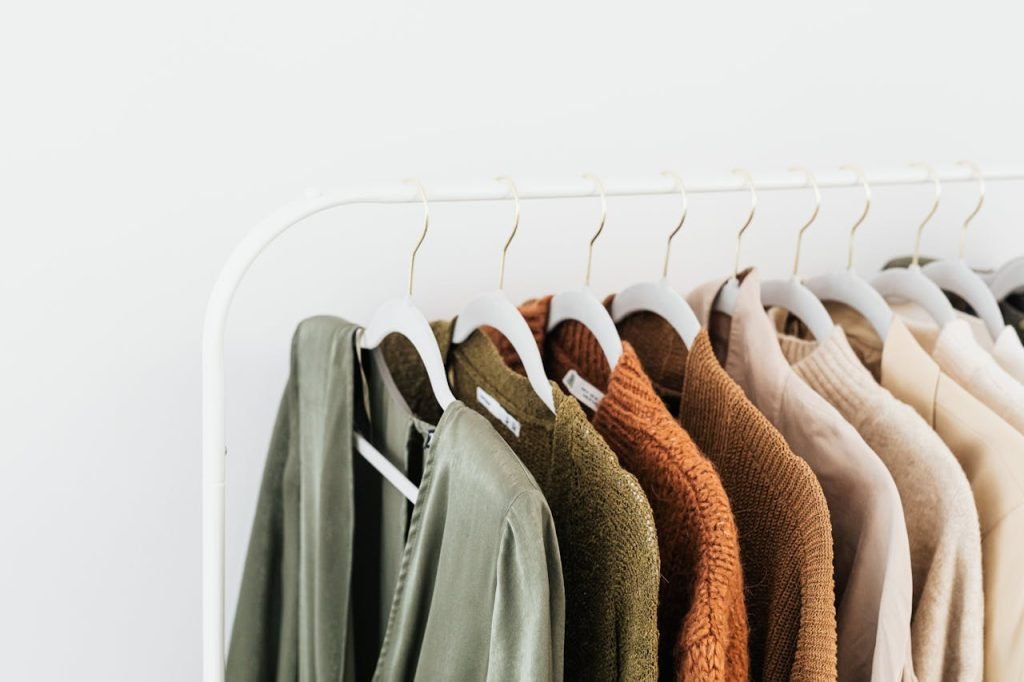 clothes-on-hangers-5706277 A minimalist display of colorful sweaters and shirts on white hangers.
