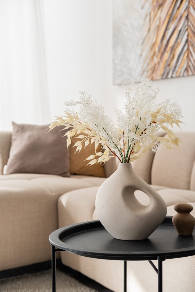 Elegant vase with dried flowers on a modern coffee table in a bright living room